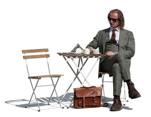 cut out man in a suit sitting in an outdoor cafe