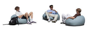 three young men sitting in bean bag chairs