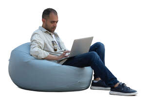 man sitting in a bean bag chair with laptop