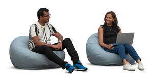 man and woman sitting on bean bag chairs and working with computer