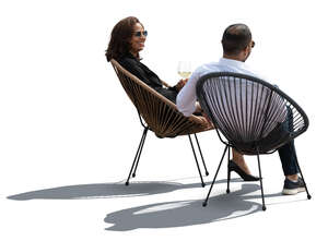 two cut out backlit people sitting in acapulco chairs and talking