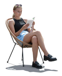 cut out backlit woman sitting on balcony chair and reading a book