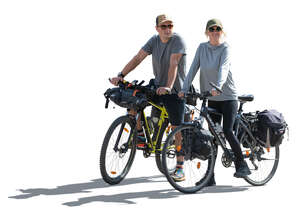 two backlit people travelling on bikes