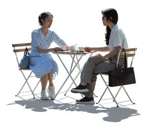 backlit asian women sitting in a cafe and talking