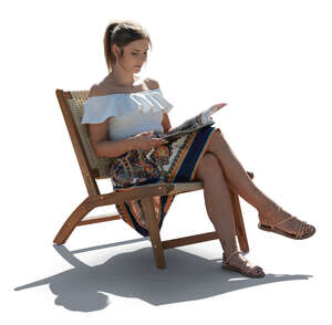 woman sitting in an armchair outside and reading a magazine