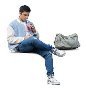 young sporty man sitting and drinking smoothie