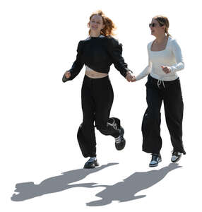 backlit image of two teenage girls running hand in hand