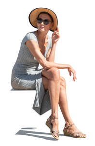 cut out woman in a dress and wearing a hat sitting