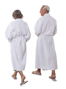 older man and woman in bathrobes walking