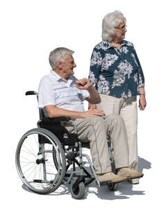 elderly man sitting in a wheelchair and an elderly woman standing