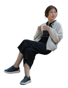 asian woman sitting and drinking coffee