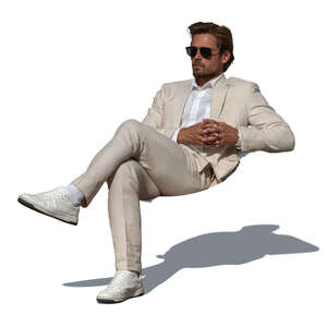 man in a white suit sitting on a sofa