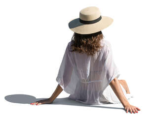 woman with a hat and in a light summer dress sitting