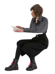 woman sitting at a desk and reading a book