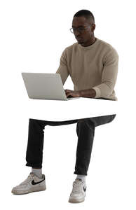 cut out black man sitting and working with a computer