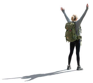 backlit woman with hiking backpack standing arms stretched out