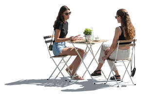 cut out backlit scene of two women sitting in a cafe outside