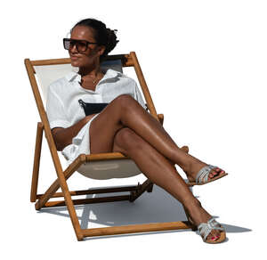 woman in a white shirt dress sitting in a beach sling chair