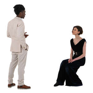 man in a white suit talking to a woman sitting