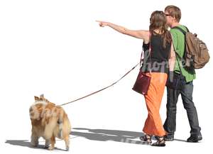 couple walking a dog and pointing at smth