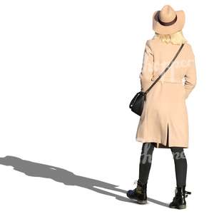 woman wearing a beige coat and hat walking