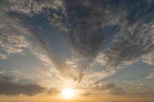 sun setting behind dark clouds