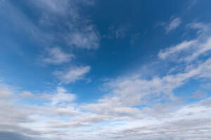 deep blue sky with scattered white clouds