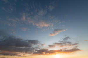 sunset with sun and small clouds