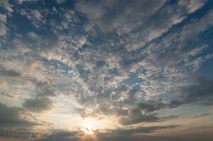 sunset with sun behind small clouds