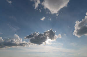 day sky with sun behind a small cloud