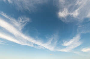 daytime sky with a line of thin clouds