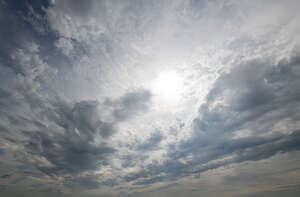 sky covered with thin grey clouds and sun shining