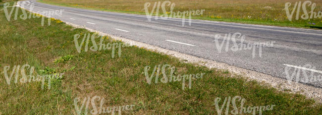 asphalt road between grasslands