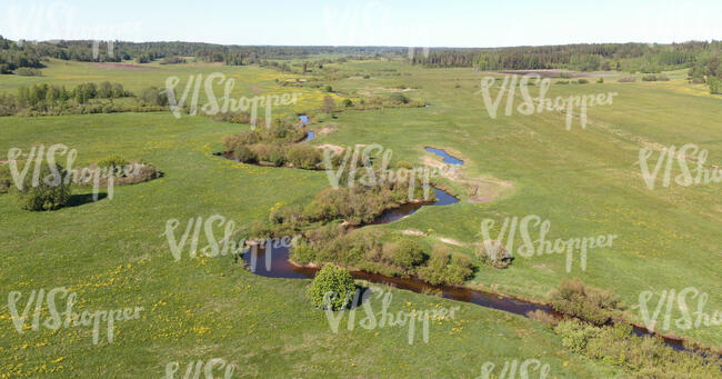 aerial view of a creek between grasslands