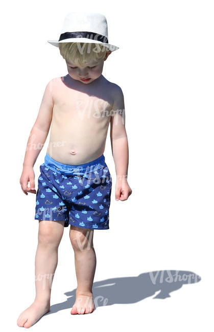 little boy with a hat standing on the beach