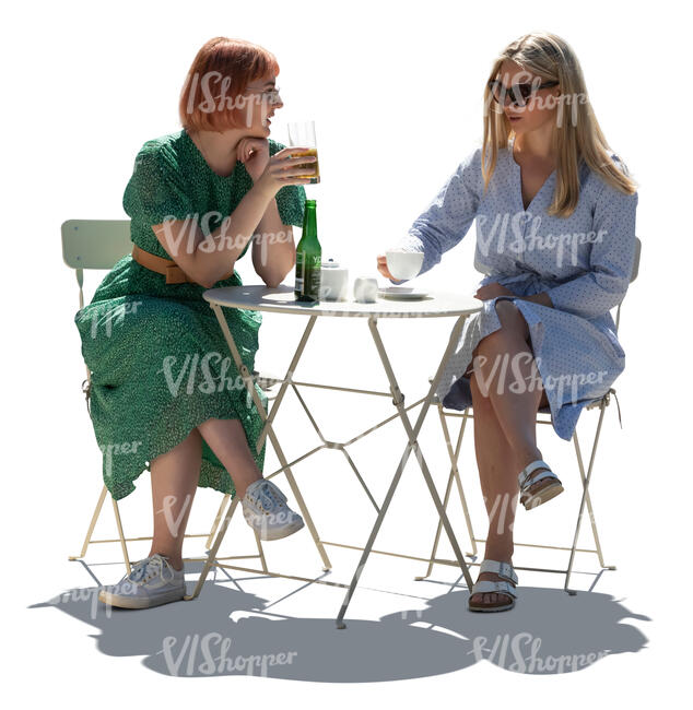 two cut out backlit young women sitting in a cafe and talking