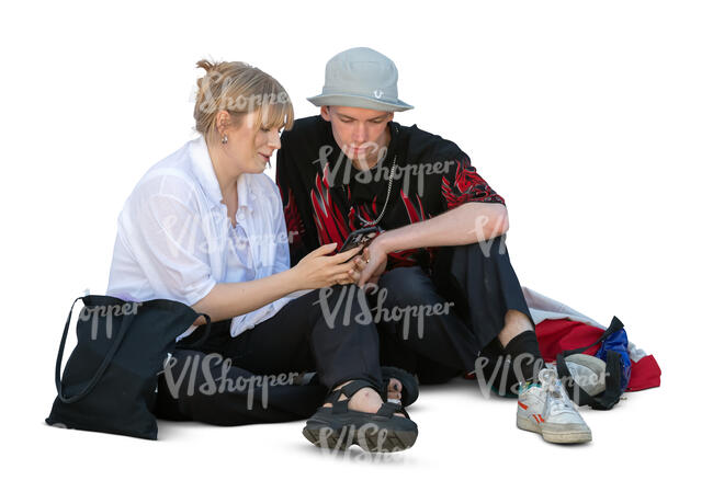 cut out man and woman sitting on the ground and watching smth from a smartphone