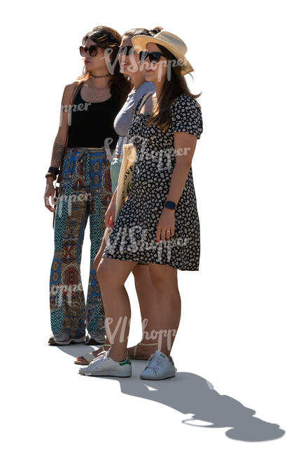 three backlit women standing