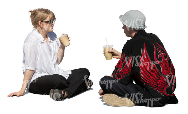 man and woman sitting outside on the ground and drinking coffee