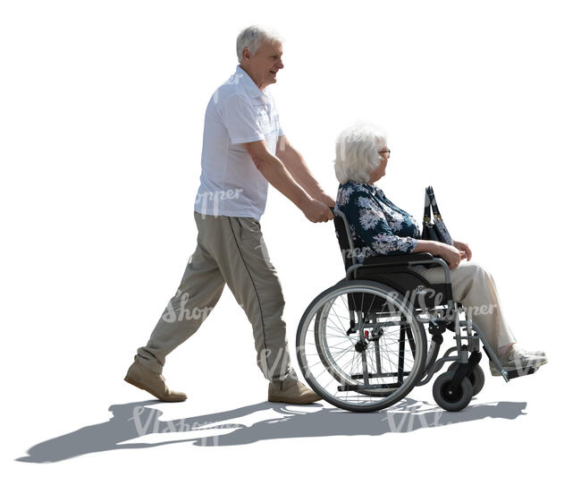 backlit man pushing a woman in a wheelchair