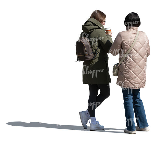 two women drinking coffee outside in autumn