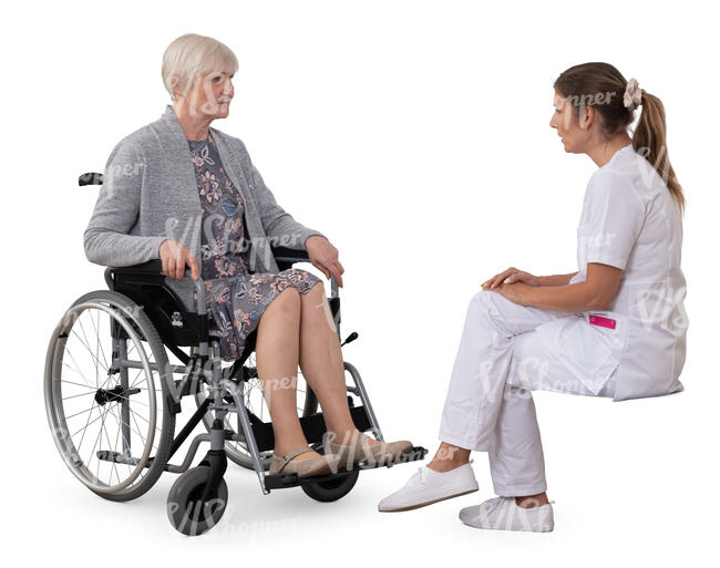older woman in a wheelchair talking to a medical worker