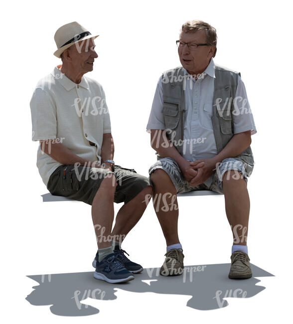 two backlit older men sitting and talking