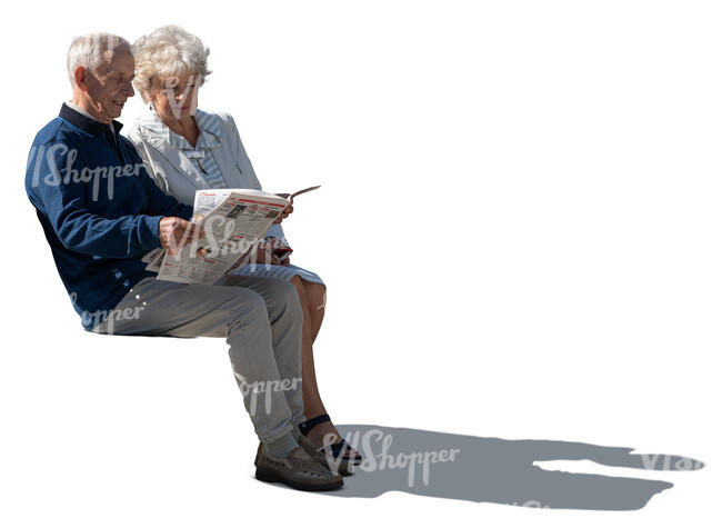 sidelit elderly couple sitting and reading a newspaper