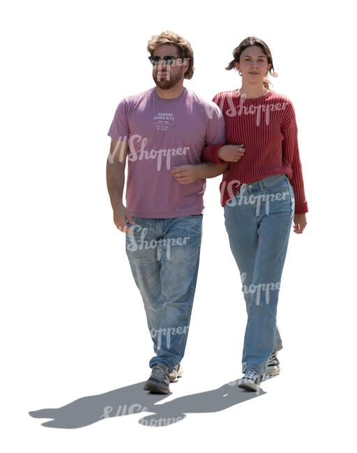 two backlit people walking arm in arm