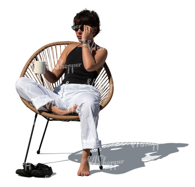 cut out woman sitting on a patio chair and drinking coffee