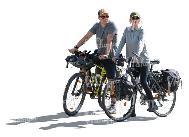 two backlit people travelling on bikes