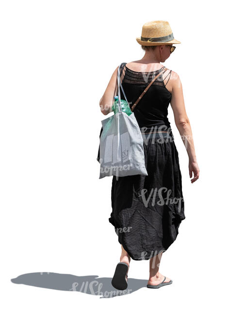 woman in a black summer outfit and wearing a hat walking