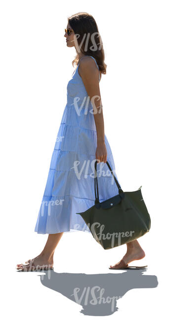 backlit woman in a summer dress walking