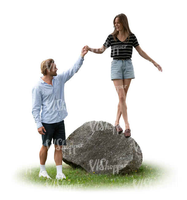 man helping a woman to climb on a rock